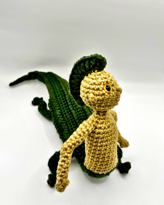 Crocheted alligator and human figure on a white background